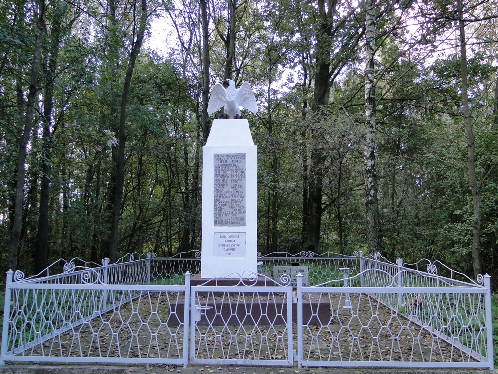 Pomnik betonowy z orłem u góry -"CZEŚĆ MĘCZENNIKOM POLEGŁYM W LATACH 1939 – 1945 w RADOMICACH