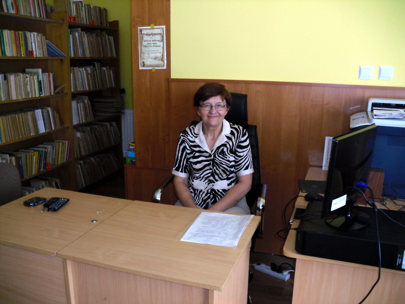 Bibliotekarka zasiada za biurkiem...