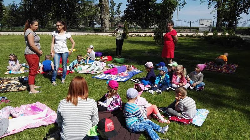 Kilkoro grup dzieci siedzących...