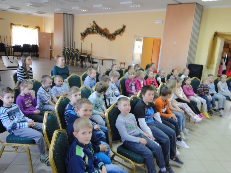 Uczniowie siedzący na krzesłach...
