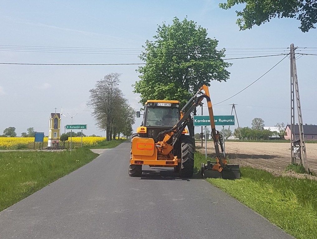 Maszynista w ciągniku obcina rowy drogowe