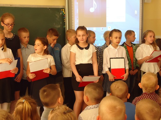 Dzieci w strojach galowych podczas wykonywania uroczystości