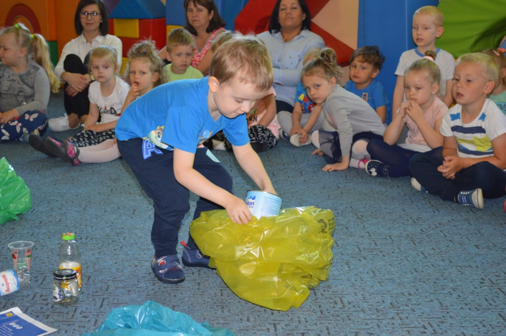 Uczeń segregujący odpady na tle innych osób