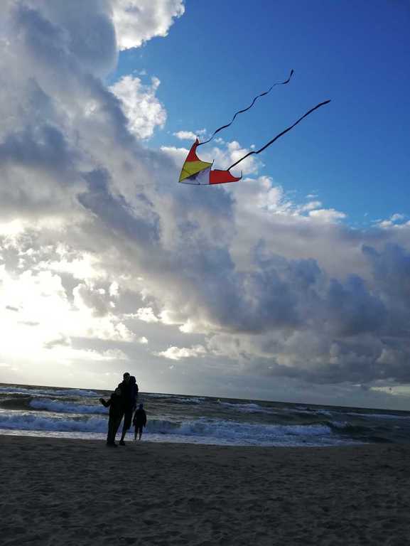 Latawiec nad plażą. Rodzina z dzieckiem.