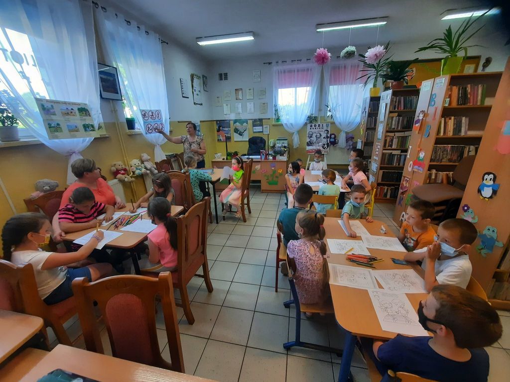 Na zdjęciu Pani bibliotekarka prezentuje ,,Praktyczne rady na wakacje.