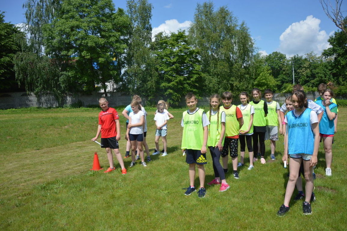 Uczniowie w trzech rzędach przygotowujący się do biegów sztafetowych