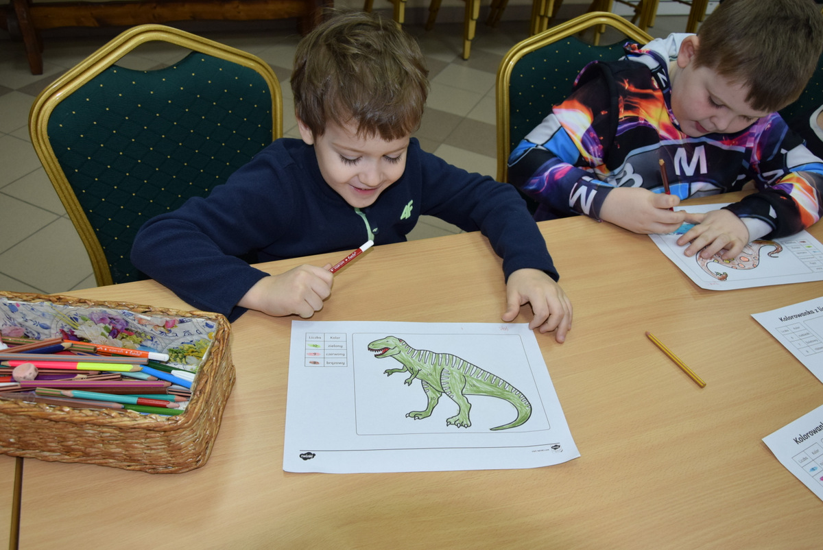 1. Chłopiec prezentuje pracę plastyczną