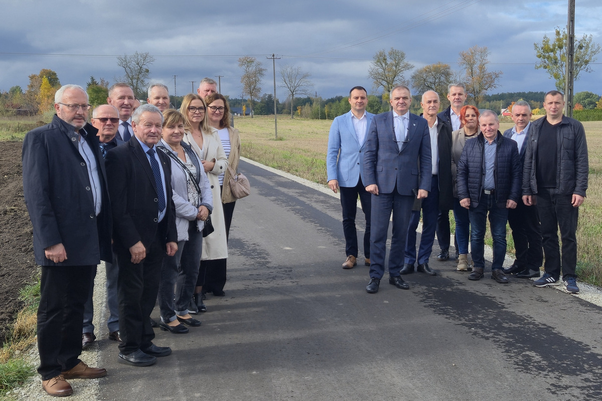 Wyjazd radnych Gminy Lipno w terenie - Grupa osób stojąca na nowej nawierzchni bitumicznej