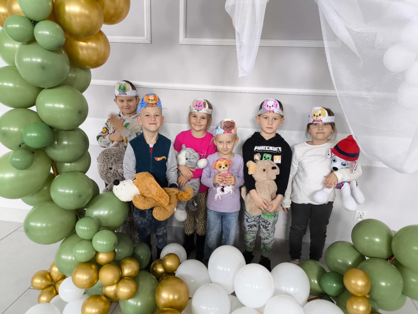 Dzieci na pamiątkowym zdjęciu z opaskami z podobizną pieska