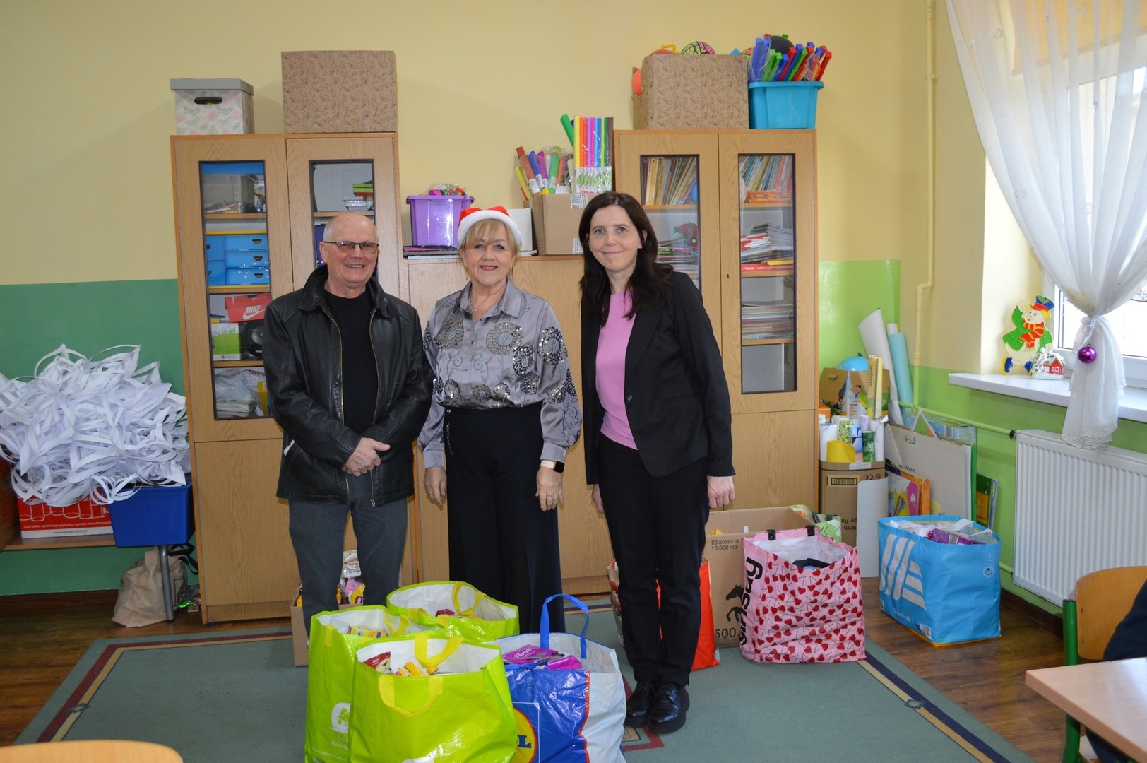 Na zdjęciu od lewej: mężczyzna, obok dwie kobiety. Z przodu przygotowane paczki dla seniorów.