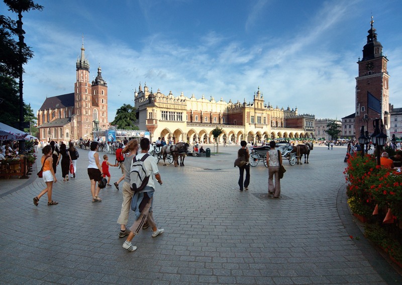 Zdjęcie przedstawia ludzi spacerujących po rynku. (link otworzy duże zdjęcie)
