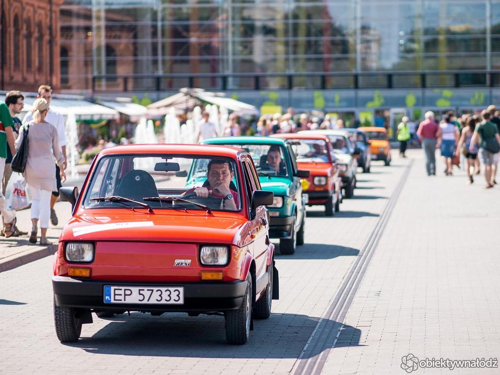 Zdjęcie przedstawia przejazd samochodów Fiat 126p przez miasto.