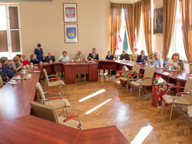 Jubilaci z ich rodzinami w towarzystwie burmistrza Żnina siedzący przy stołach auli Urzędu Miejskieg