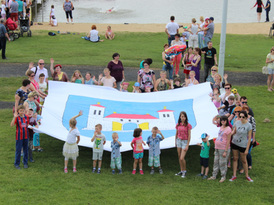 Zdjęcie grupy osób trzymających flagę z herbem Gminy Żnin