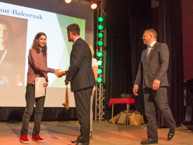 Przewodniczący Rady Miejskiej w Żninie wręcza wyróżnienie sportowcowi