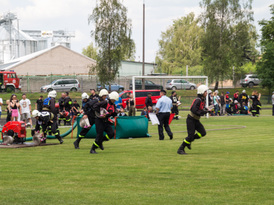Strażacy rozwijający wąż podczas zawodów