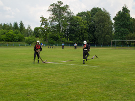 Strażacy rozwijający wąż podczas zawodów