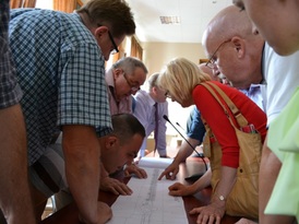 Uczestnicy konsultacji pochylający się nad planem ścieżki rowerowej