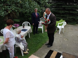 Sekretarz Gminy Mirosław Gatka wręcza bukiet kwiatów solenizantce