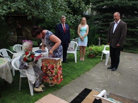 Zastępca Kierownika Urzęu Stanu Cywilnego Barbara Skibicka wręcza prezent solenizantce