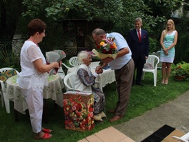 Mężczyzna wręcza bukiet kwiatów solenizantce