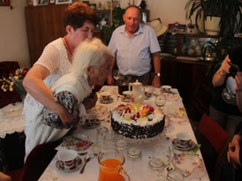 100-latka zdmuchuje świeczki z urodzinowego tortu