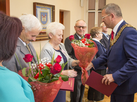 Burmistrz Żnina wręcza bukiety kwiatów jubilatom