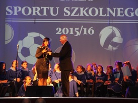 Dyrektor Zespołu Publicznych Szkół Marek Orzechowski wręcza kobiecie czerwoną różę