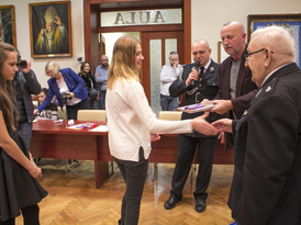 Delegacja Miejsko-Gminnego ZOSP oraz Pan Andrzej Łuczak wręczający dyplomy i czekolady dzieciom i mł