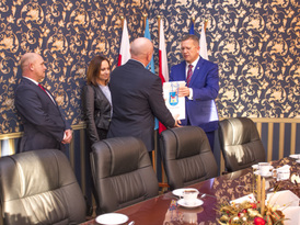 Burmistrz składa gratulacje dyrektorowi szkoły i wręcza drobny upominek z gadżetami gminnymi