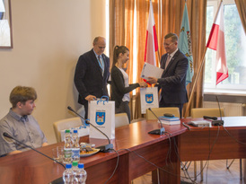 Burmistrz wręcza uczennicy podziękowanie oraz drobny upominek