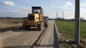 Prace równiarki przy uzupełnianiu podbudowy drogi