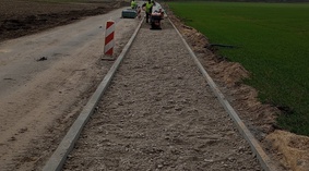 Budowa chodnika. Wbudowanie podbudowy z kruszywa łamanego na odcinku drogo od km 0+800 do km 1+102.