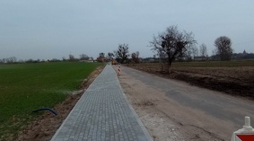 Budowa chodnika. Wykonanie podsypki cementowo piaskowej oraz układanie kostki brukowej na odcinku d