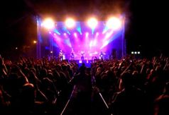 Koncert zespołu muzycznego ukazujący kolorowe światła i wizualizacje towarzyszące występującemu zesp