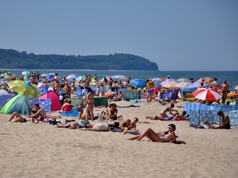 Turyści wypoczywający na plaży we Władysławowie, w tle przylądek Rozewie.
