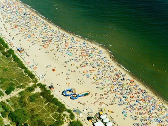 Widok z lotu ptaka na plaże i wypoczywających turystów we Władysławowie.