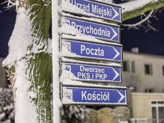 Drogowskaz informacyjny, ukazujący kierunek lokalizacji poszczególnych instytucji w mieście, pokryty