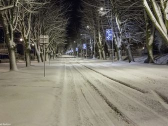 Aleja Żeromskiego ze świątecznymi ozdobami w postaci podświetlonych gwiazdek na słupach, pokryte śni