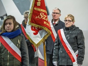 Delegacja NSZZ Solidarność wraz ze sztandarem i polskimi szarfami, uczestnicząca we mszy świętej.