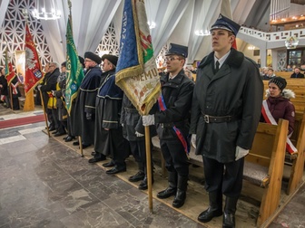 Przedstawiciele policji oraz pozostałe delegacje stojące w pierwszym rzędzie podczas mszy świętej.