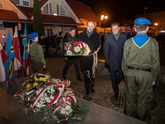 Władze powiatowe, składające wiązankę kwiatów pod pomnikiem.