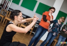 Prowadząca przedstawiająca jedno z ćwiczeń podczas warsztatów teatralnych.