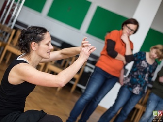 Prowadząca przedstawiająca jedno z ćwiczeń podczas warsztatów teatralnych.