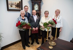 Kilkoro ludzi stoi z kwiatami