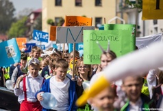 Przemarsz uczniów SP3 z okazji święta patrona szkoły - kolorowo poprzebierane dzieci idą w korowodzi