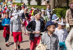 Przemarsz uczniów SP3 z okazji święta patrona szkoły - kolorowo poprzebierane dzieci idą w korowodzi