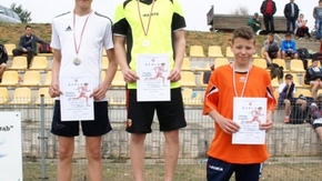 zwycięzcy pozują do zdjęcia stojąc na podium