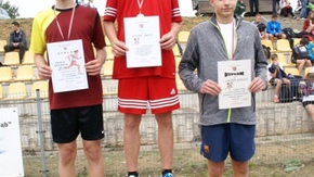 zwycięzcy pozują do zdjęcia stojąc na podium