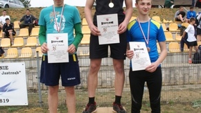 zwycięzcy pozują do zdjęcia stojąc na podium